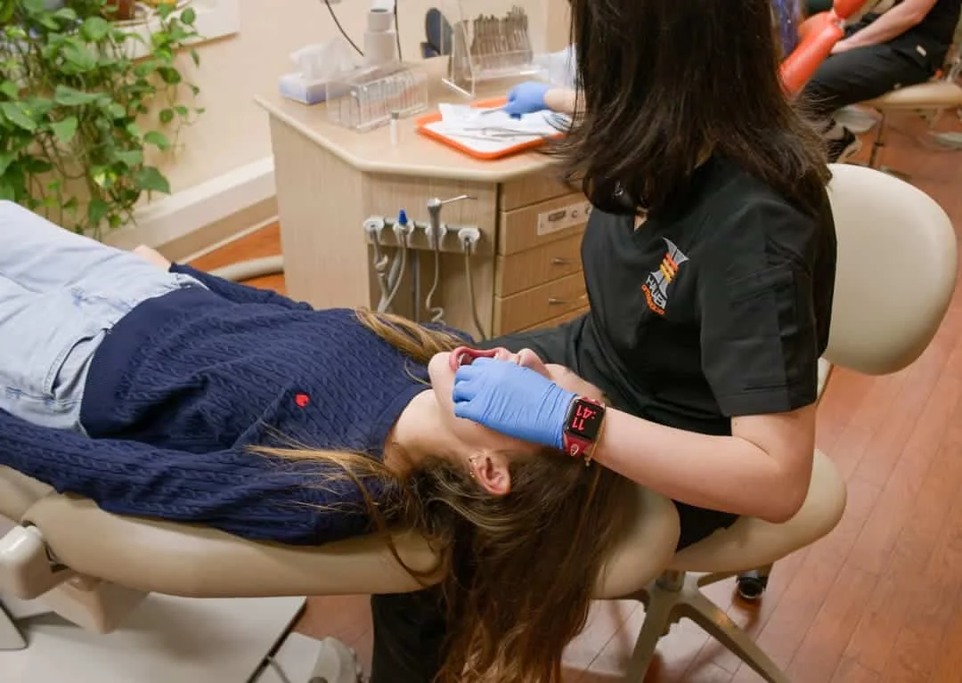 A clinical assistant providing orthodontic care to a patient at Halabi Orthodontics